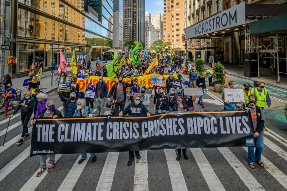 A crowd of climate activists marching behind a banner. A coalition of climate, Indigenous and racial justice groups gathered at Columbus Circle to kick off Climate Week with the Climate Justice Through Racial Justice march, Sept. 20, 2020. (Photo by Erik McGregor/LightRocket via Getty Images)