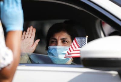 A new U.S. citizen sits in a vehicle while being sworn in by an immigration service officer at a drive-in naturalization ceremony amid the COVID-19 pandemic on July 29, 2020 in Santa Ana, California. (Mario Tama/Getty Images)