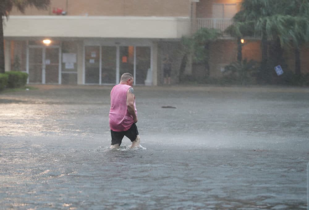 A man walks though a flooded parking lot as the outer bands of Hurricane Sally come ashore on Sept. 15, 2020 in Gulf Shores, Alabama. The storm is bringing heavy rain, high winds and a dangerous storm surge from Louisiana to Florida. (Joe Raedle/Getty Images)