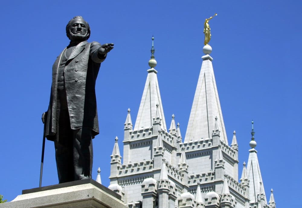 A statue of Brigham Young, second president of the Church of Jesus Christ of Latter Day Saints stands in the center of Salt Lake City with the Mormon Temple spires in the background 19 July 2001. (George Frey/AFP via Getty Images)