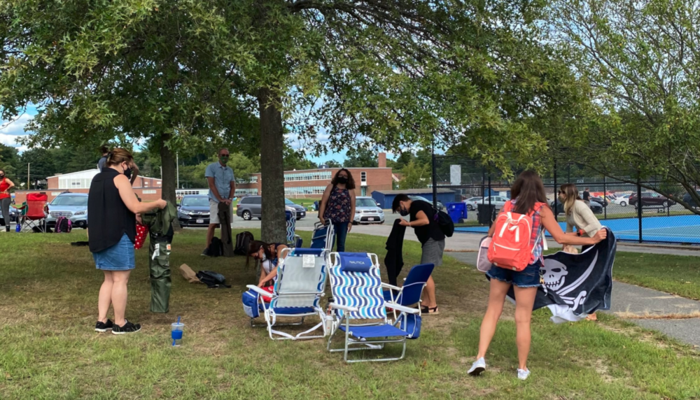 Andover teachers pick up their laptops and lawn chairs to go home after working outside in front of Andover High School on Aug. 31. (Cristela Guerra/WBUR)