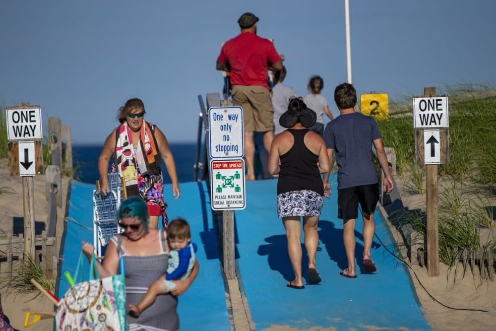 Signs and railings are set up to create one way lanes on and off the beach to maintain social distancing at Nauset Beach in Orleans. (Jesse Costa/WBUR)