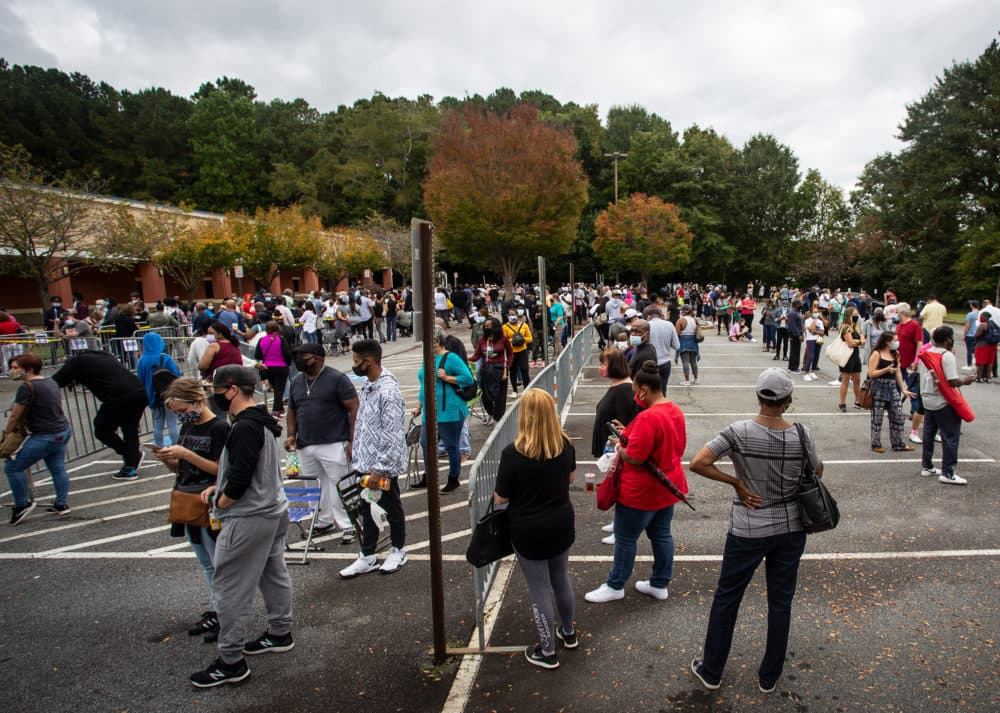Hundreds of people wait in line for early voting on Monday, Oct. 12, 2020, in Marietta, Georgia. Eager voters have waited six hours or more in the former Republican stronghold of Cobb County, and lines have wrapped around buildings in solidly Democratic DeKalb County. (Ron Harris/AP Photo)