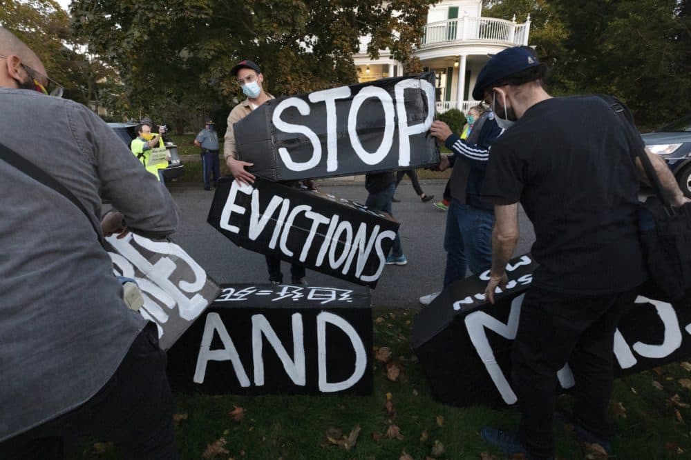 Housing activists erect a sign in front of Gov. Charlie Baker's house, Oct. 14, 2020, in Swampscott, Mass. The protesters were calling on the governor to support more robust protections against evictions and foreclosures during the ongoing coronavirus pandemic. (Michael Dwyer/AP)
