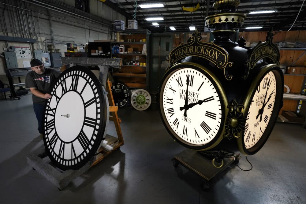 Dan LaMoore rolls a tower clock face across the plant floor at Electric Time Company, Friday, Oct. 23, 2020, in Medfield, Mass. Daylight saving time ends at 2 a.m. local time Sunday, Nov. 1, 2020, when clocks are set back one hour. (Elise Amendola/AP)