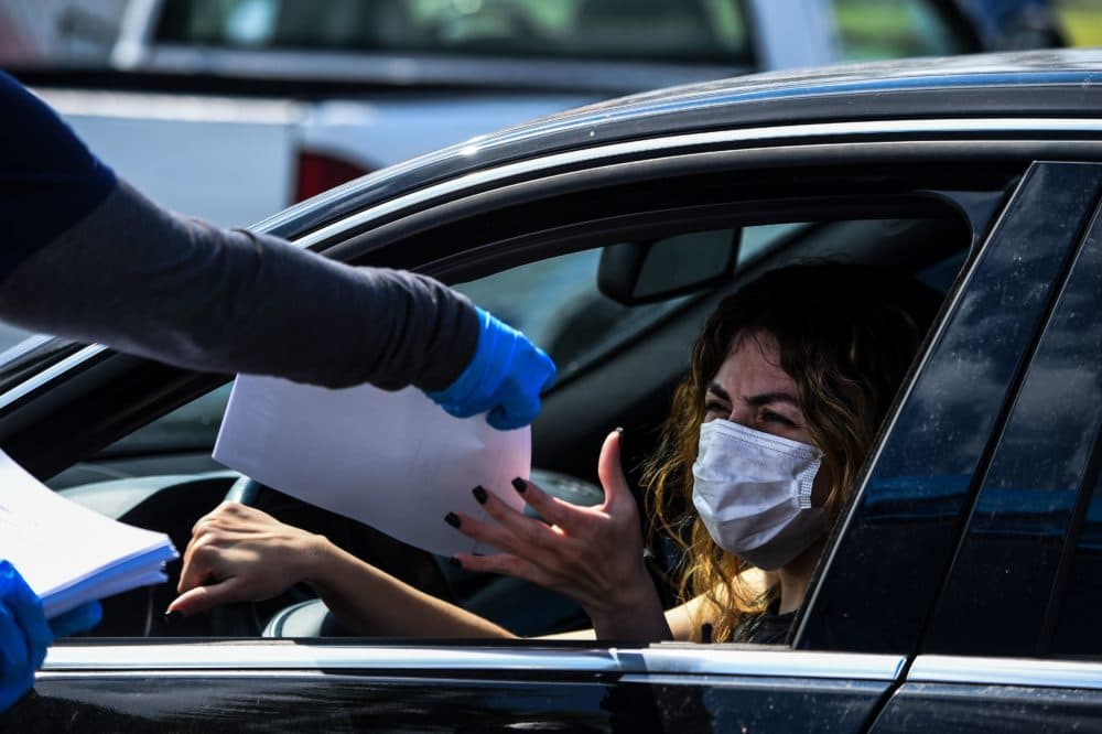 A woman collects unemployment forms at a drive through collection point outside John F. Kennedy Library in Hialeah, Florida, on April 8, 2020. (CHANDAN KHANNA/AFP via Getty Images)