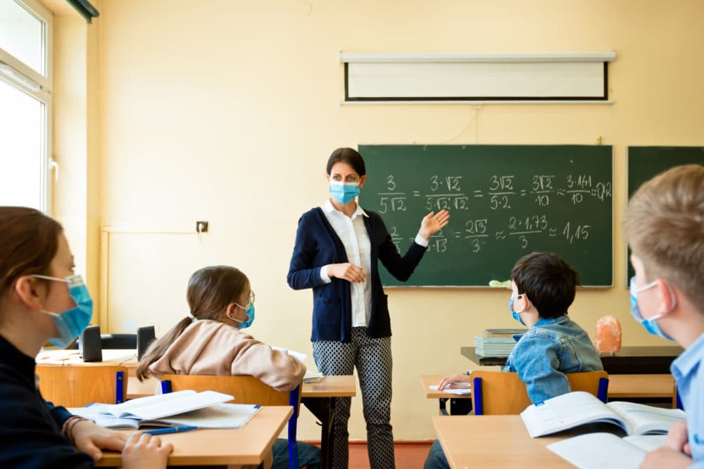 A teacher wearing a mask teaches mathematics. (Getty Images)