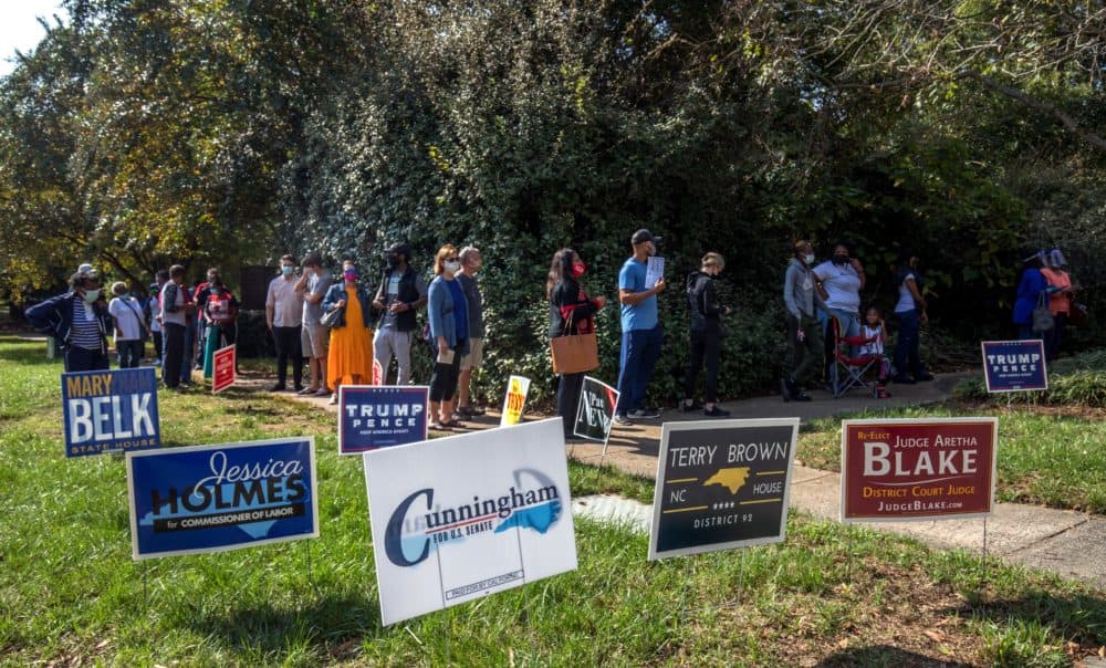 Voters in Charlotte, North Carolina, wait in line to cast their ballots at the West Boulevard branch of the Mecklenburg County library on October 15, 2020, the first day of early voting. (Grant Baldwin/AFP via Getty Images)
