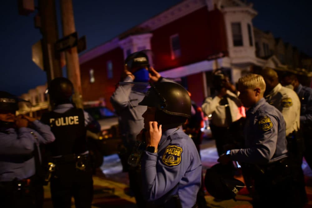 Police strap themselves into their tactical helmets before reinforcing a barricade line facing demonstrators near the location where Walter Wallace Jr. was killed by two police officers on October 27, 2020 in Philadelphia, Pennsylvania. (Mark Makela/Getty Images)