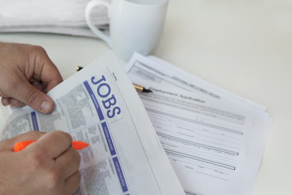 A person browses job postings in a newspaper. (Getty Images)