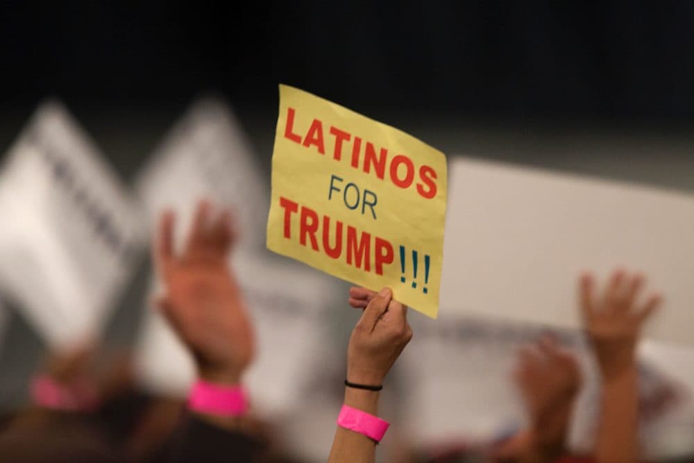 A woman holds a sign expressing Latino support for Republican presidential candidate Donald Trump at his campaign rally at the Orange County Fair and Event Center, April 28, 2016, in Costa Mesa, California. (David McNew/AFP via Getty Images)