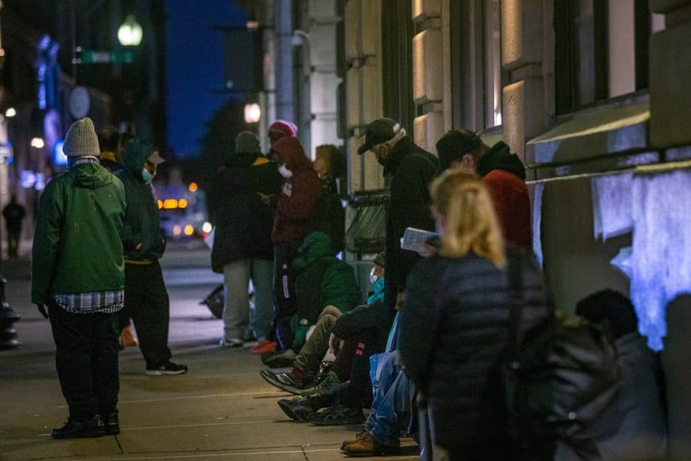 People experiencing homelessness stand in line outside St. Francis House in Boston, in October 2020, waiting for the day shelter to open. (Jesse Costa/WBUR)