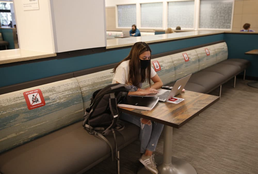 BU Sophomore Katherine Pacheco sits alone to do remote schoolwork inside the George Sherman Union Food Hall on Sept. 23, 2020. According to a BU survey, about half of BU’s students plan to stay in Boston for Thanksgiving. A quarter plan to travel home and return to Boston. (Photo by Jessica Rinaldi/The Boston Globe via Getty Images)