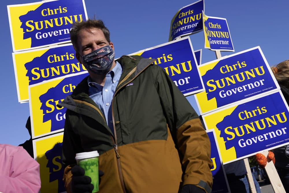 N.H. Gov. Chris Sununu stands with supporters at a polling station in Windham on Tuesday. (Charles Krupa/AP)