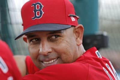 In this Feb. 18, 2019, file photo, Boston Red Sox manager Alex Cora smiles from behind the batting cage during their first full squad workout at their spring training baseball facility in Ft. Myers, Fla. (Gerald Herbert/AP File)