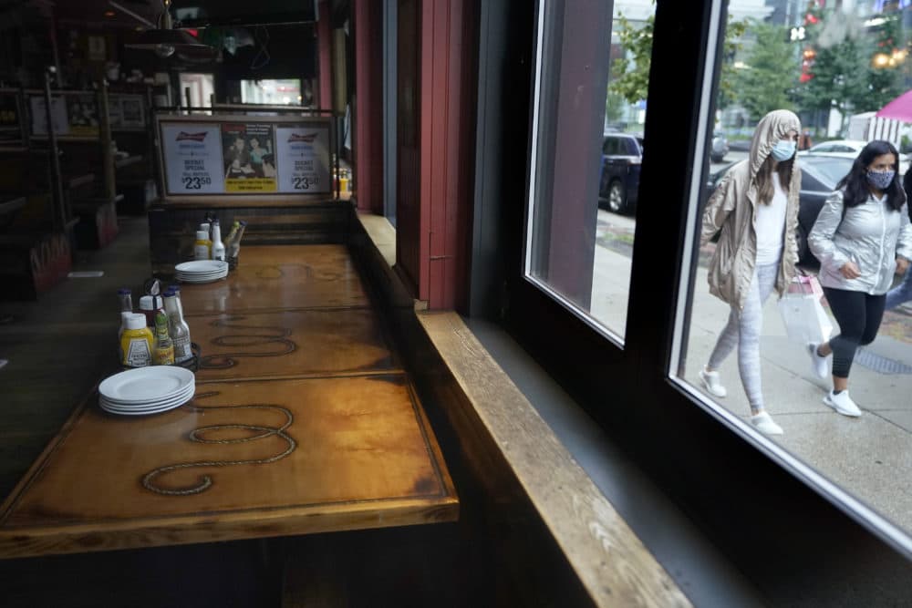 Passersby walk past an empty restaurant in September in Boston. (Steven Senne/AP)