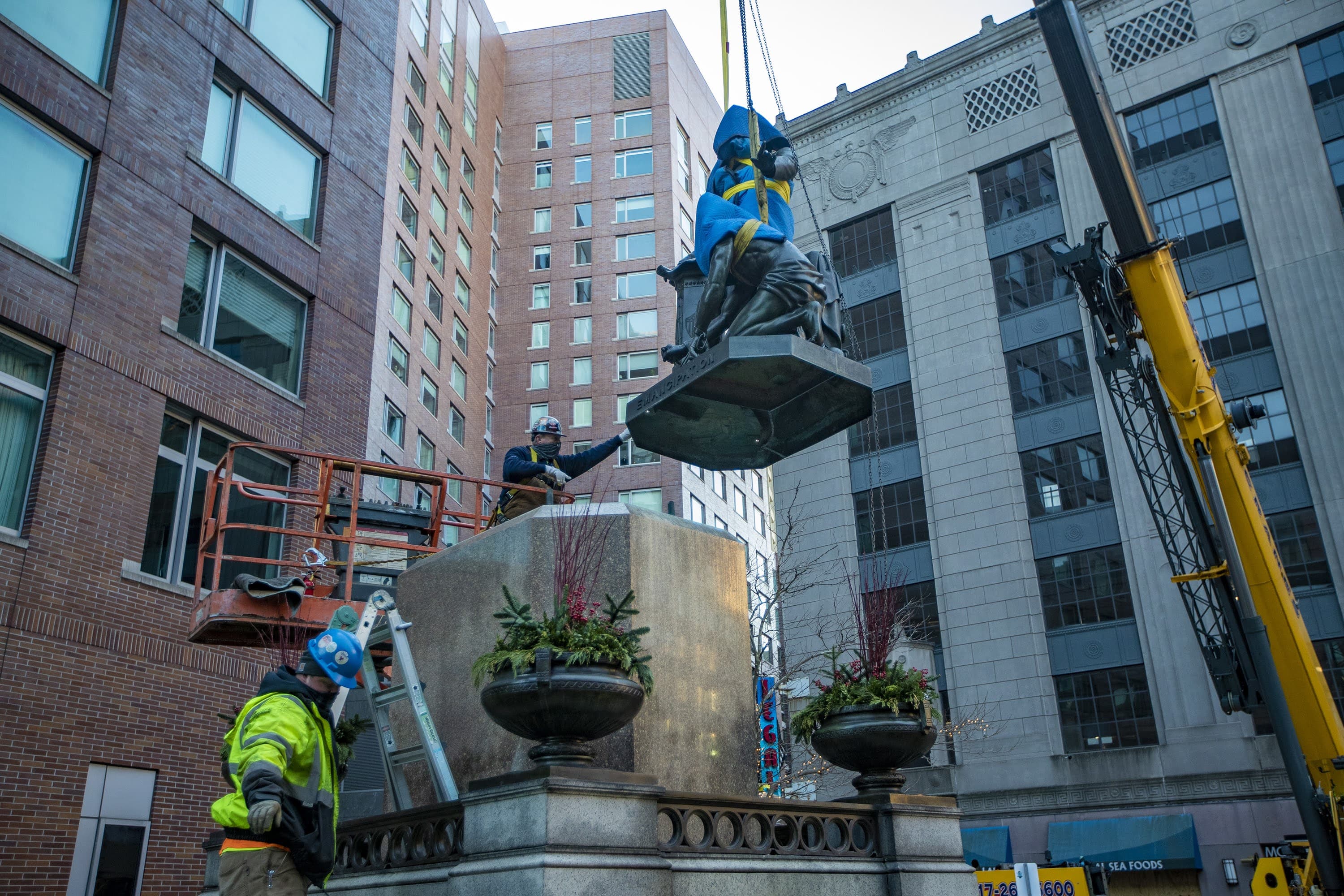 Workers remove the “Emancipation Group” statue from its pedestal in Park Square. (Jesse Costa/WBUR)