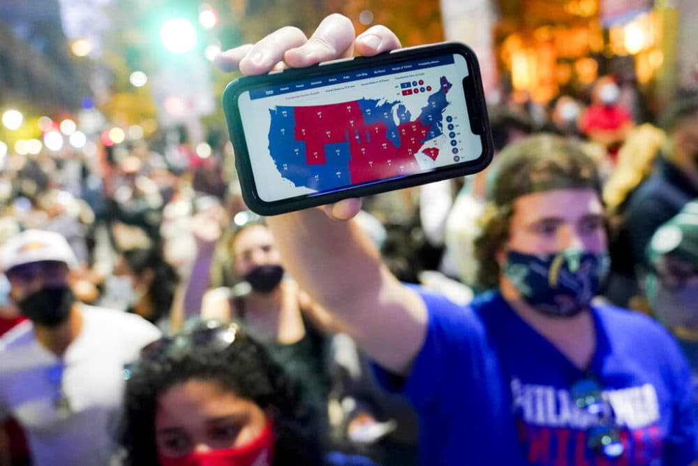 A supporter of President-elect Joe Biden holds up his mobile phone to display the electoral college map outside the Philadelphia Convention Center after the 2020 Presidential Election is called, Saturday, Nov. 7, 2020, in Philadelphia. (John Minchillo/AP Photo)