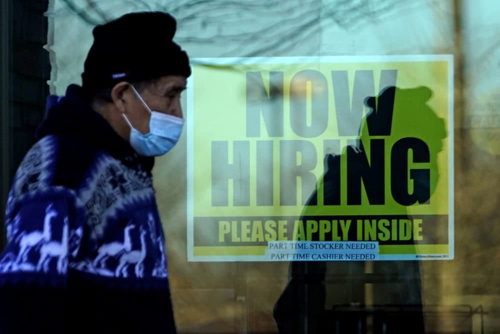 A shopper wears a face mask and he walks past a store displaying a hiring sign in Wheeling, Ill., Nov. 28, 2020. (Nam Y. Huh/AP)