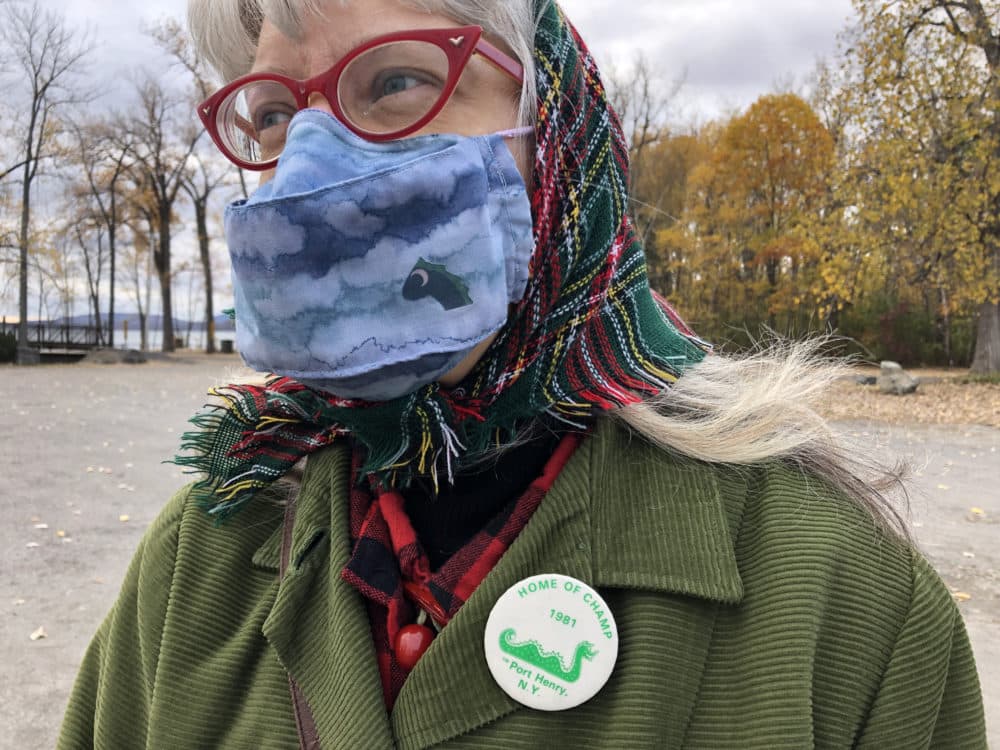 Andrea Anesi of Port Henry's Chamber of Commerce wears a homemade lake monster face mask and a Champ promotion pin from the 1980s. (Julia Press)
