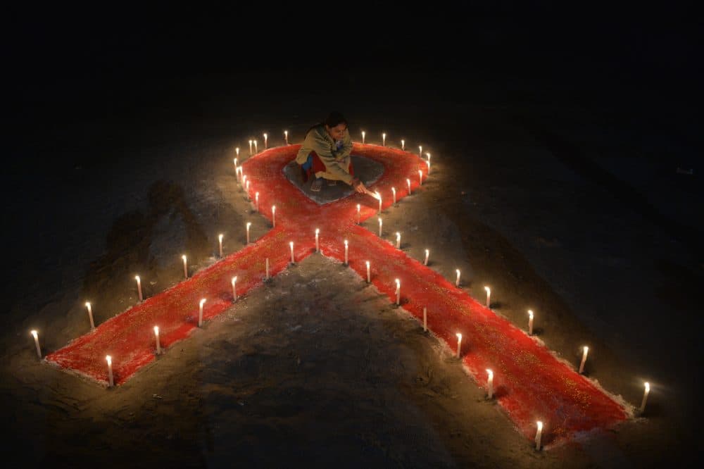 An Indian sex worker lights candles forming the shape of a ribbon as part of an awareness event on the occasion of World AIDS Day in Siliguri on December 1, 2018. - World AIDS Day has been observed today since 1988 to raise awareness of the AIDS pandemic. (Diptendu Dutta/AFP via Getty Images)