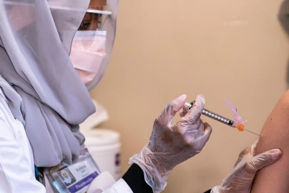 Fetiya Omer, a pharmacist, administers a COVID-19 vaccine to a health care worker at the University Of Washington Medical Center on December 15, 2020 in Seattle, Washington. (David Ryder/Getty Images)