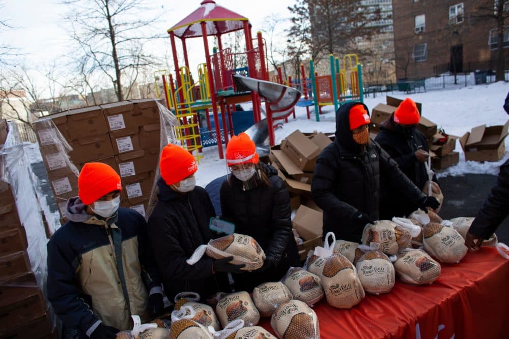 Volunteers hold turkeys during a giveaway for people in need, organized by Food Bank For New York City at Highbridge Houses in the Bronx on December 19, 2020 in New York. (Kena Betancur/AFP/Getty Images)