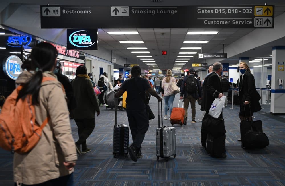 Passengers walk through a crowded terminal at Dulles International airport in Dulles, Virginia on Dec. 27, 2020 amid the coronavirus pandemic. (Photo by Andrew Caballero-Reynolds/AFP via Getty Images)