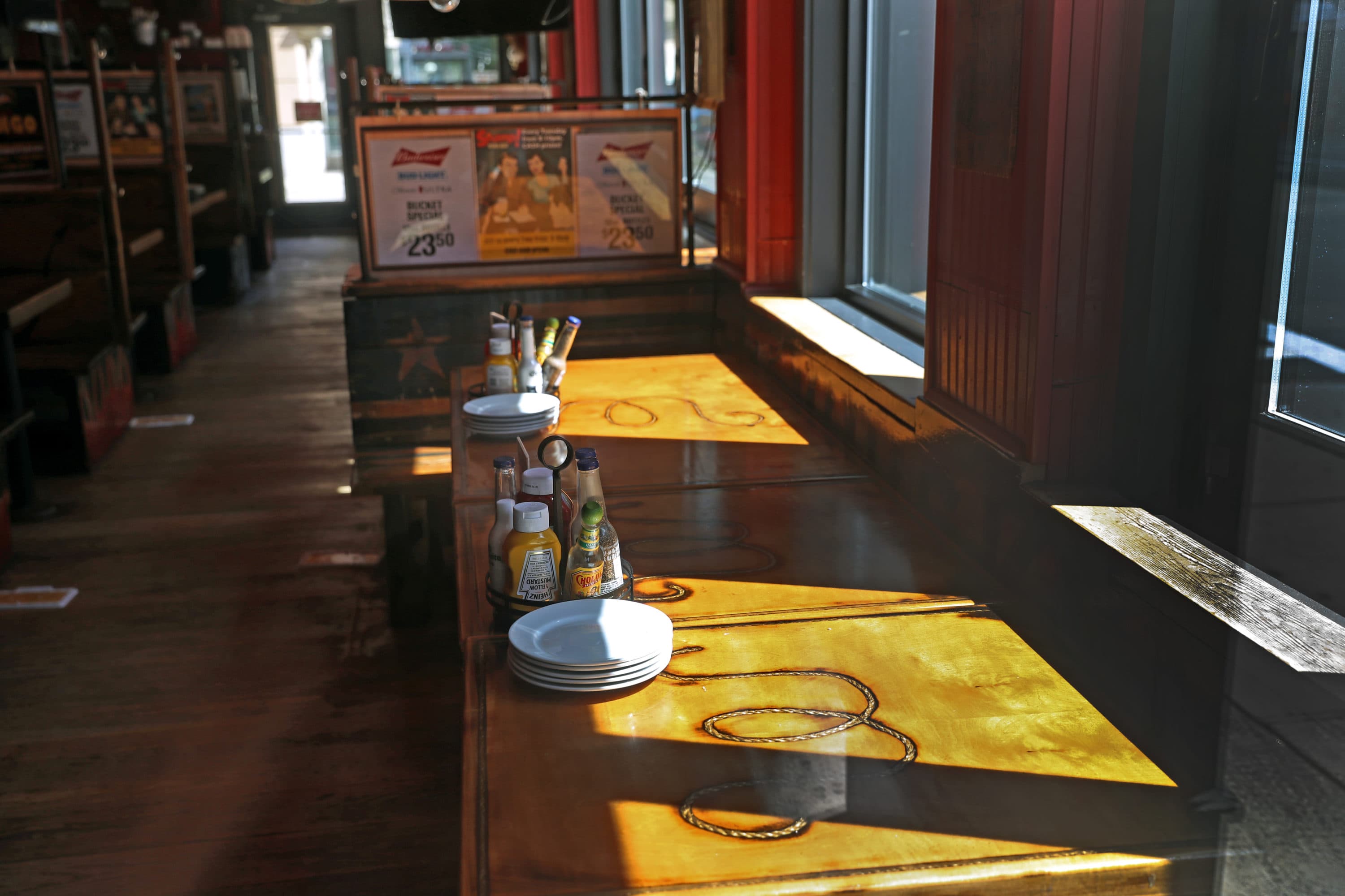Tables set in the closed Whiskey's on Boylston St. in Boston on Sept. 8. Four restaurants right next to each other the Lir, the Pour House, the McGreevey's and Whiskey's all closed down during the COVID-19 pandemic, leaving a once-bustling part of Boylston Street empty. (David L. Ryan/The Boston Globe via Getty Images)