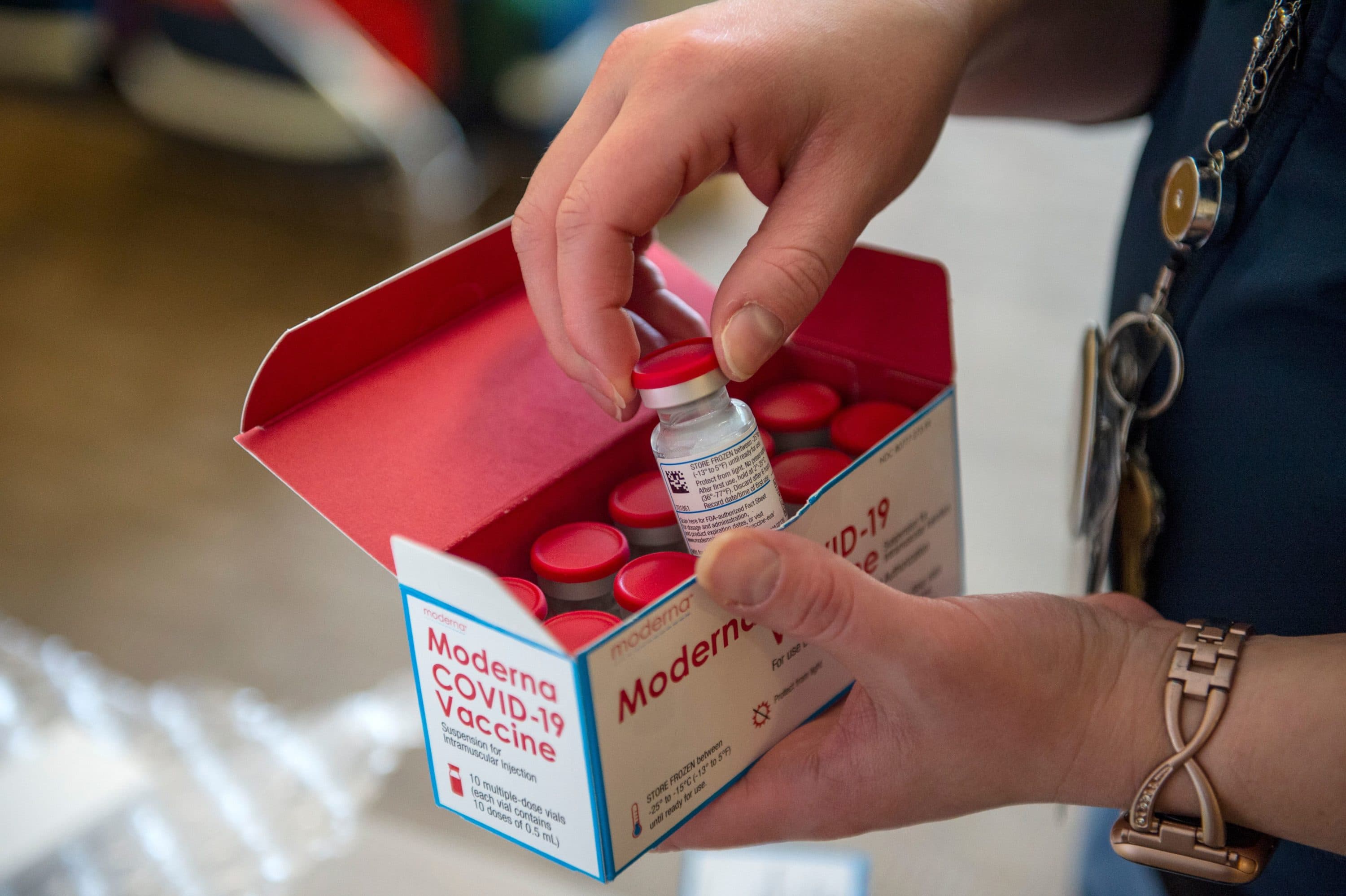 RN Courtney Senechal unpacks a special refrigerated box of Moderna COVID-19 vaccines as she prepared to ready more supply for use at the East Boston Neighborhood Health Center in Boston on Dec. 24. (Joseph Prezioso/AFP via Getty Images)