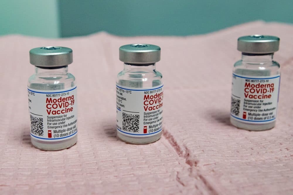 Three nearly empty bottles of the Moderna COVID-19 vaccine which can not be mixed to provide an additional dose for a vaccination shot. (Jesse Costa/WBUR)