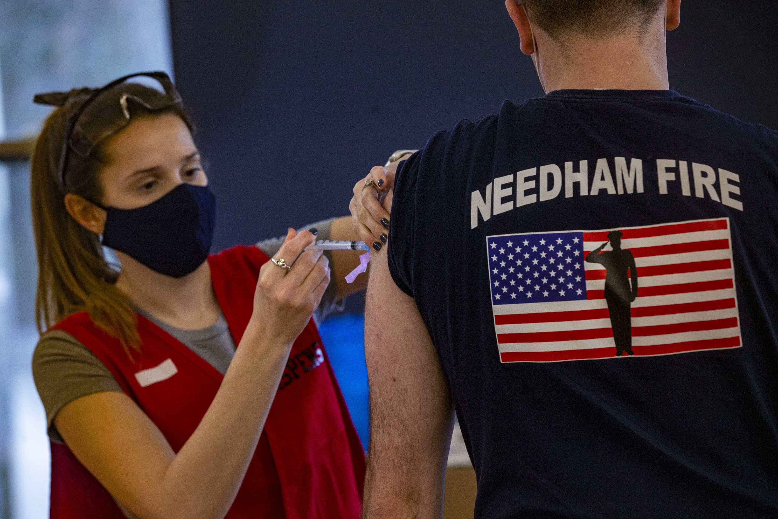 A Needham Firefighter receives the Moderna COVID-19 vaccine at Rosemary Recreational Center in Needham. (Jesse Costa/WBUR)