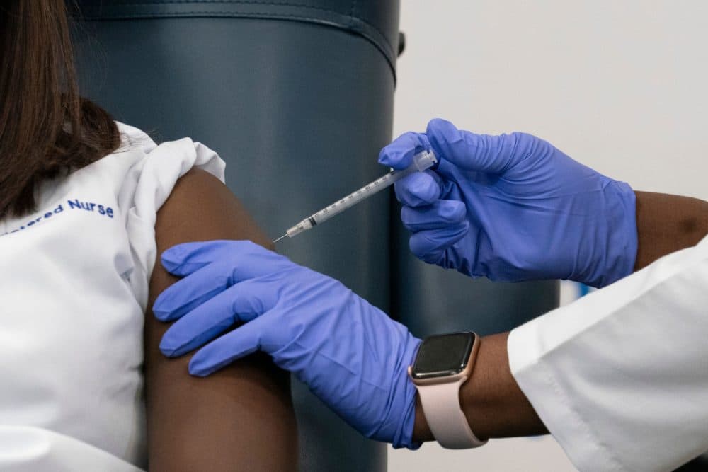 A nurse is inoculated with the COVID-19 vaccine. (Mark Lennihan/AFP via Getty Images)