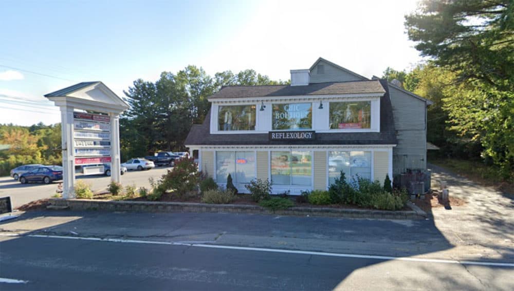 A sign atop several signs showcasing a commercial strip of businesses advertises the retail gun shop Hitman Firearms in Tyngsborough, Mass. (Screenshot via Google Maps in 2019)