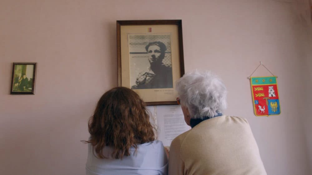 Colette Marin-Catherine (right) and Lucie Fouble look at a picture of Marin-Catherine's brother, Jean-Pierre, who died in the Mittelbau-Dora concentration camp in Germany. (Courtesy of The Guardian)