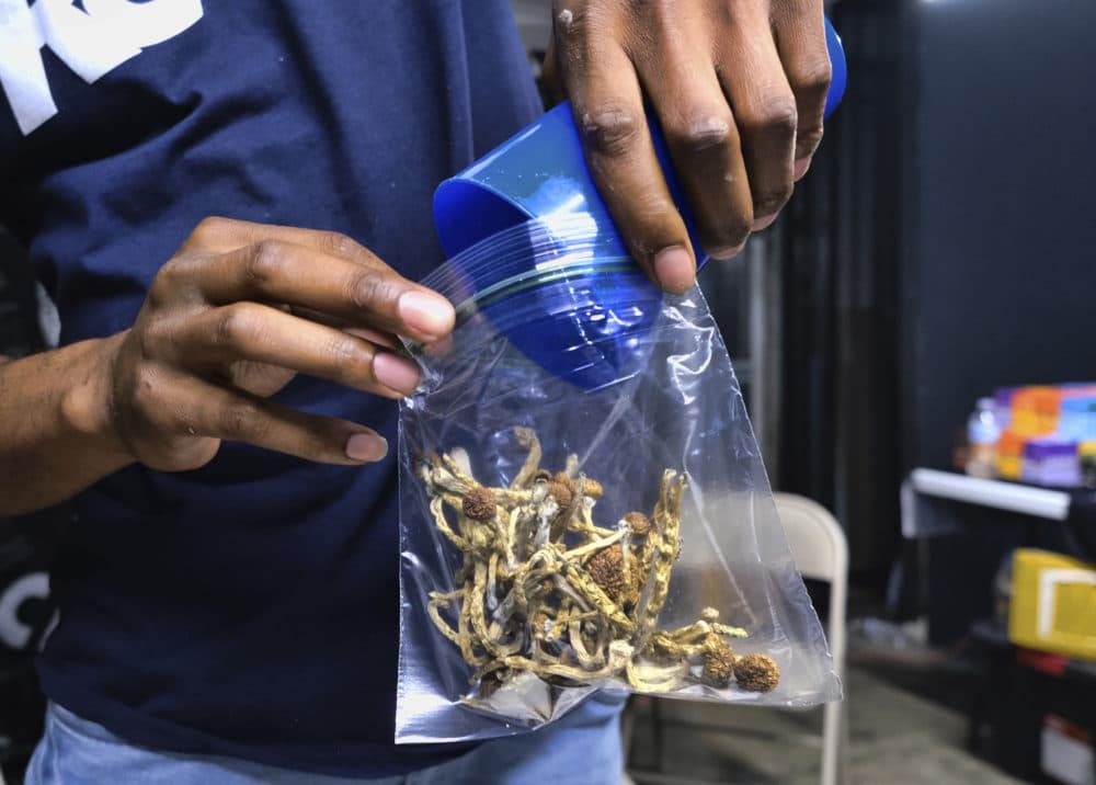 A vendor bags psilocybin mushrooms at a pop-up cannabis market in Los Angeles. Cambridge has signaled its support to decriminalize psilocybin and most other psychedelics. (Richard Vogel/AP)