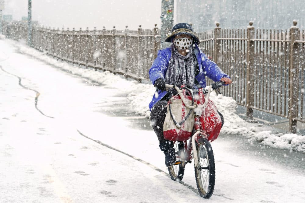 A woman rides a bicycle across the Brooklyn Bridge during a snowstorm, Sunday, Feb. 7, 2021, in Brooklyn. It was the second time in less than a week the area has been buffeted by heavy snowfall. (Kathy Willens/AP)