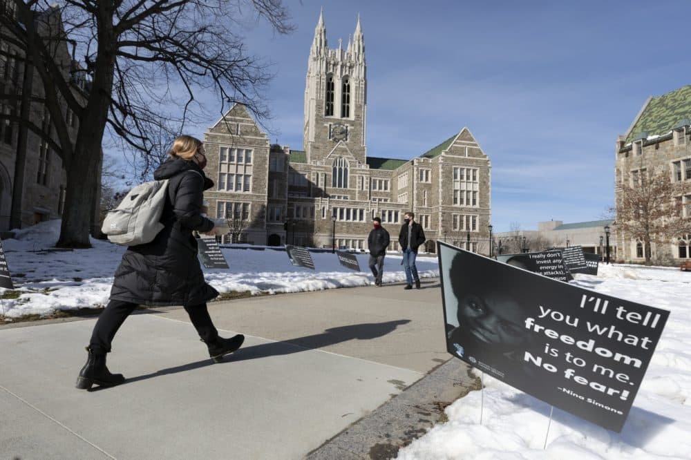 Students walk past Black History Month posters on the Boston College campus, Wednesday, Feb. 17, 2021, in Boston. Harassment by white male students targeting Black and Latina women housed in a Boston College dormitory has revived concerns about racism on campus. (Michael Dwyer/AP)
