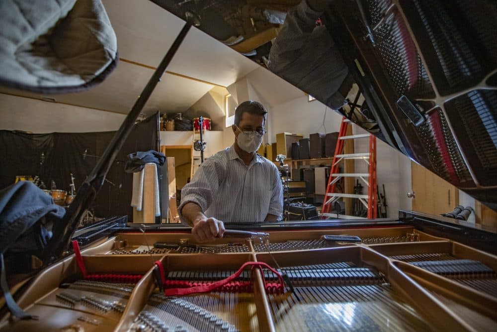 Fred Mudge uses a tuning hammer to tune a Yamaha C7 piano at the Wellspring Studio in Acton. (Jesse Costa/WBUR)
