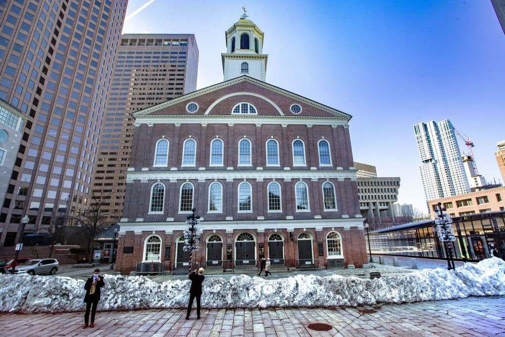 A couple of tourists stop to take phone pictures of Faneuil Hall. (Jesse Costa/WBUR)