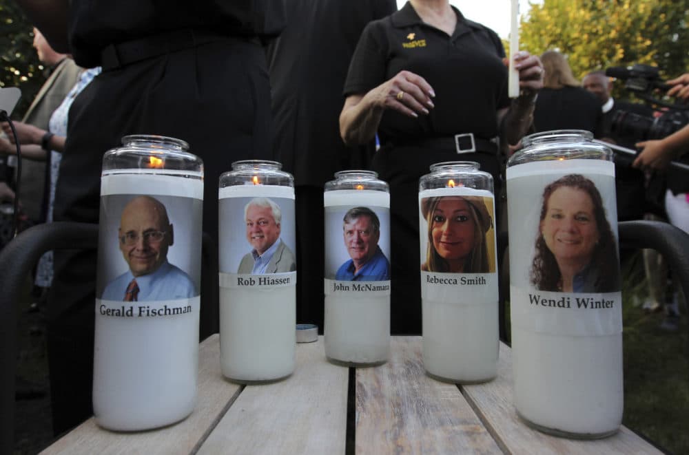 Fiveve employees of the Capital Gazette newspaper adorn candles during a vigil across the street from where they were slain in the newsroom in Annapolis, Md. (Jose Luis Magana/AP)