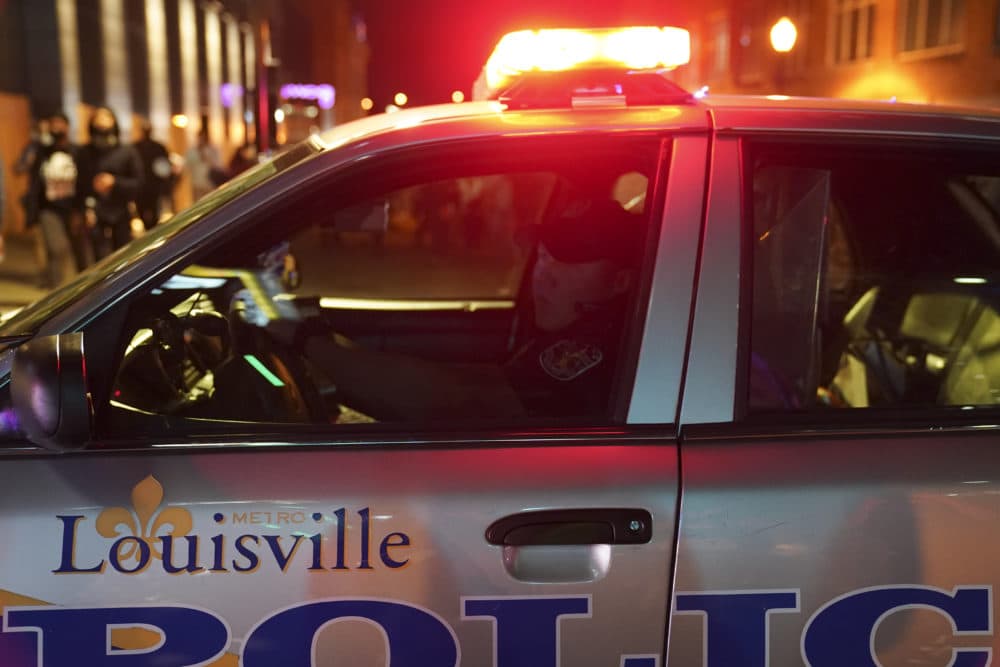 A police officer observes protesters, on Sept. 24, 2020, in Louisville, Ky. Protests in the city erupted followed the decision not to charge officers for killing Breonna Taylor. (John Minchillo/AP)
