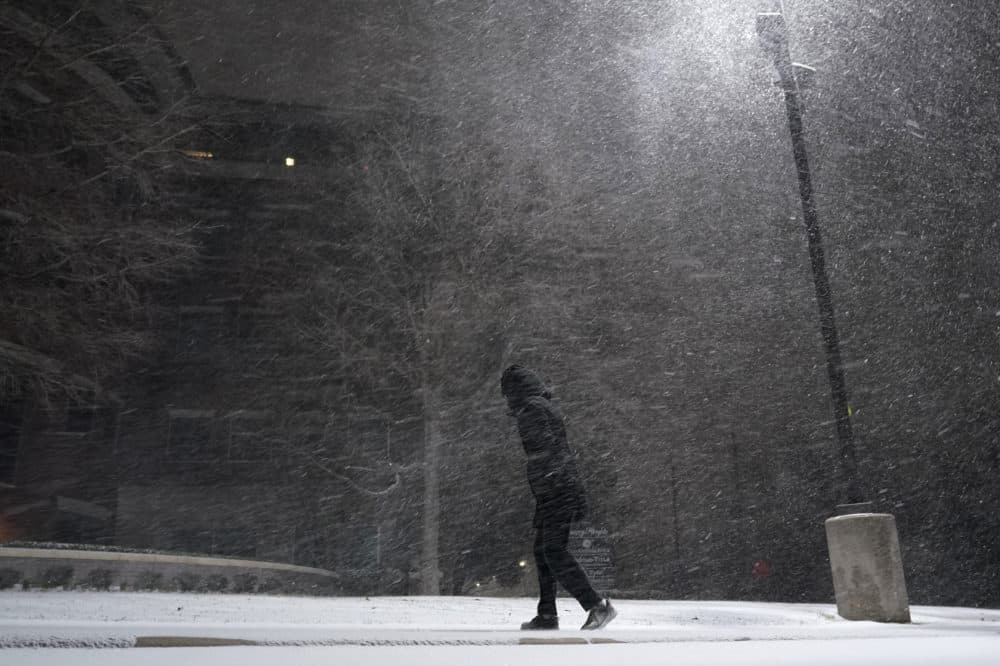 A woman walks through falling snow in San Antonio, Texas, on Sunday, Feb. 14, 2021. (Eric Gay/AP)