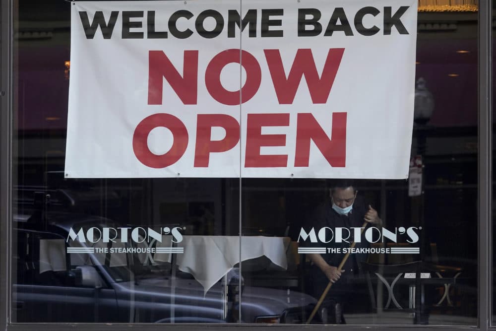 In this March 4, 2021, file photo, a sign reading &quot;Welcome Back Now Open&quot; is posted on the window of a Morton's Steakhouse restaurant as a man works inside during the coronavirus pandemic in San Francisco. (Jeff Chiu/AP File)