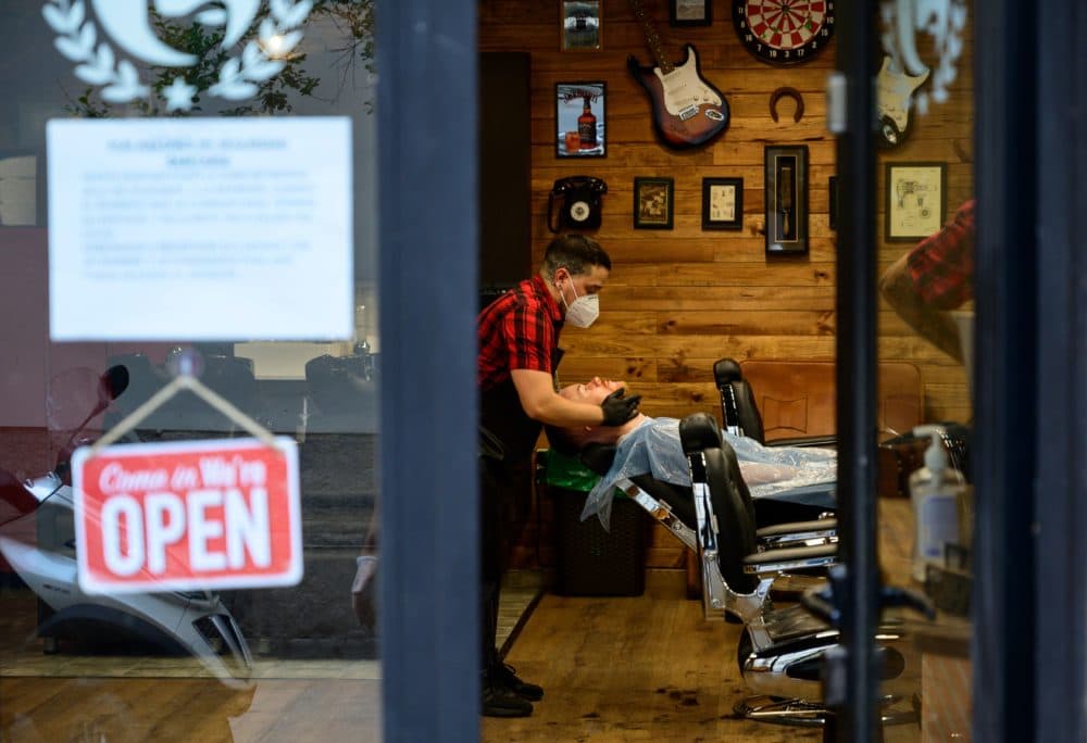 A barber attends a client after reopening his barber shop on May 4, 2020. (Pierre-Philippe Marcou/AFP via Getty Images)