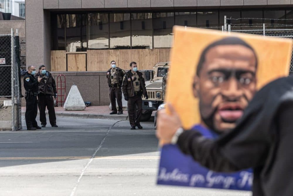 A demonstrator holds a portrait of George Floyd outside the Hennepin County Government Center in Minneapolis, Minnesota. The high-profile trial of former officer Derek Chauvin began on March 29. (Kerem Yucel/AFP/Getty Images)