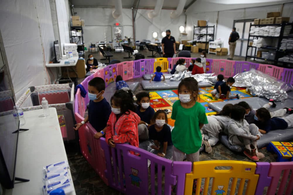 Young unaccompanied migrants ages 3 to 9 watch TV inside a playpen at the Donna Department of Homeland Security holding facility, the main detention center for unaccompanied children in the Rio Grande Valley in Donna, Texas, on March 30, 2021. (Dario Lopez-Mills/POOL/AFP via Getty Images)