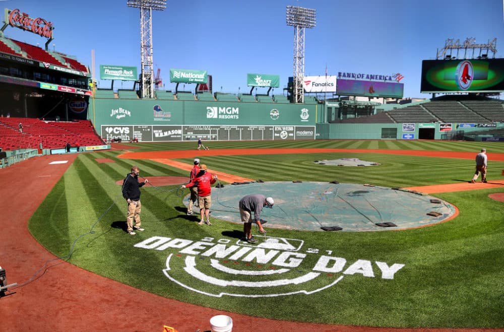 A worker spray-paints &quot;Opening Day&quot; behind home plate at Fenway Park in Boston on March 30, 2021.  (John Tlumacki/The Boston Globe via Getty Images)