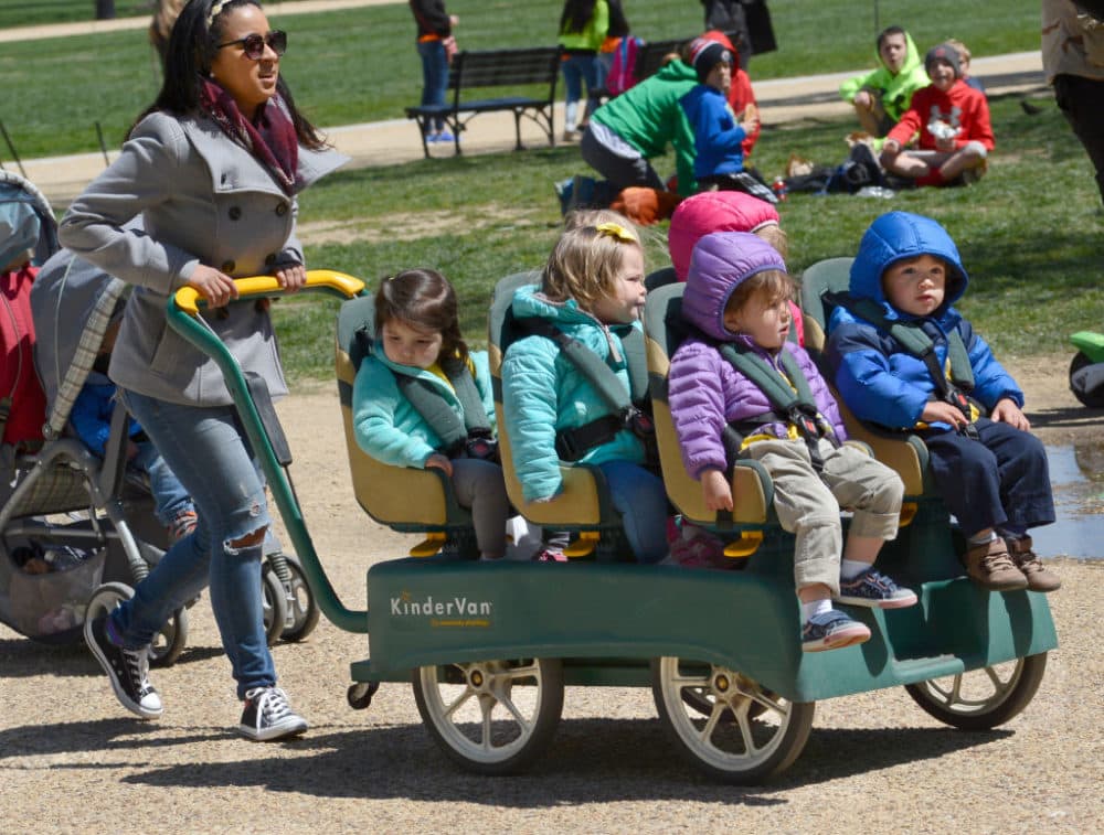 A daycare center employee pushes a KinderVan filled with preschool children on an outing along the National Mall in Washington, D.C. (Robert Alexander/Getty Images)
