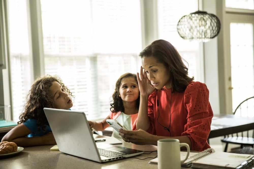 A mother tries to work with her children at home. (Getty Stock Image)